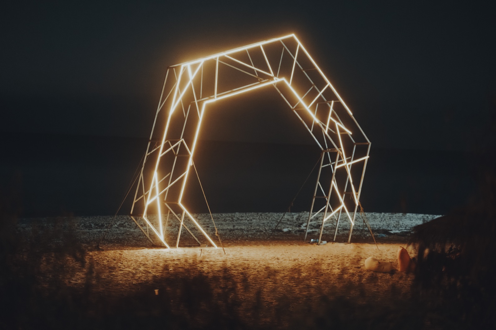 Une installation lumineuse sur la plage, de nuit