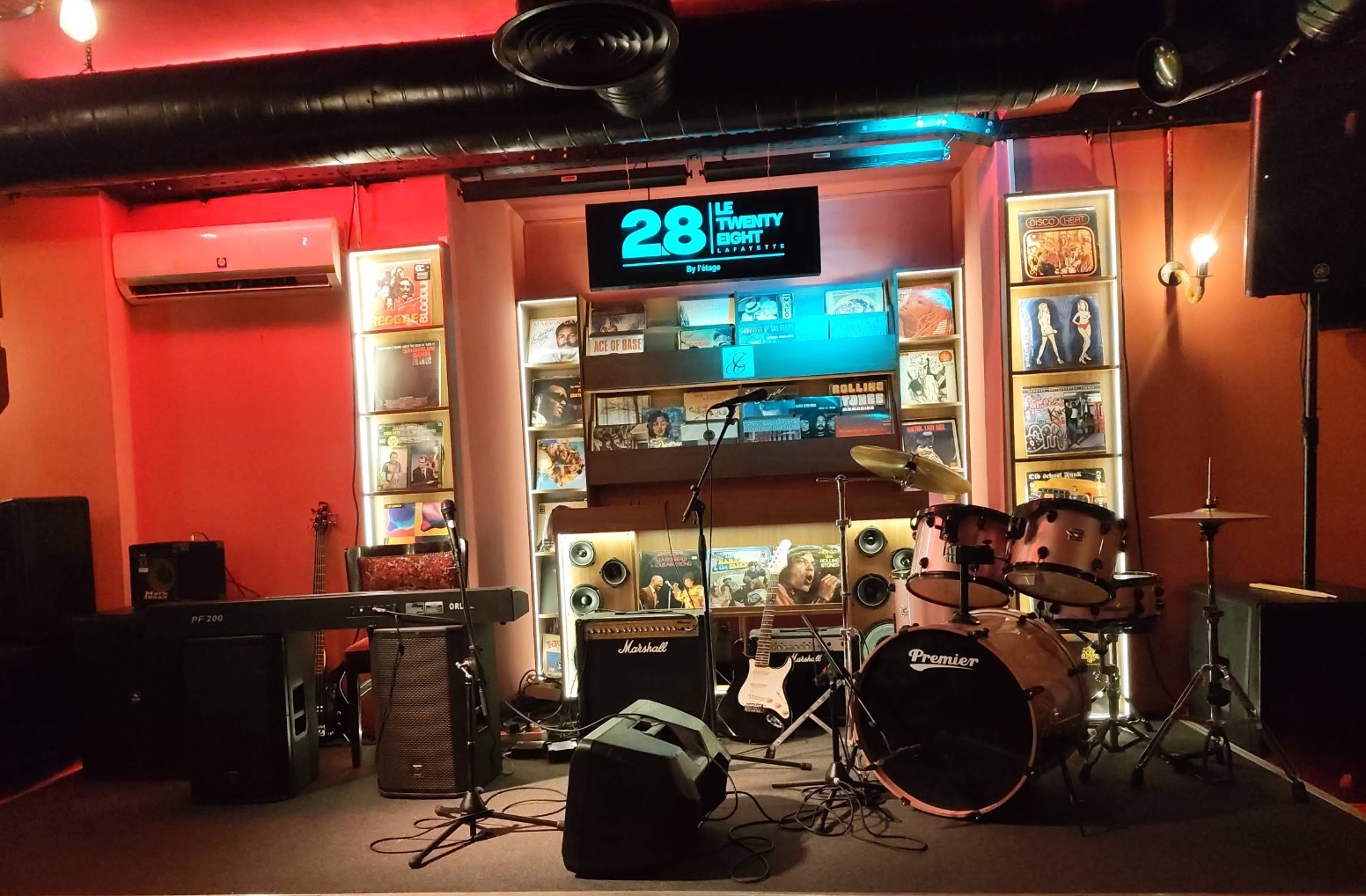 La scène du Twenty Eight avant le concert : l'enseigne, le mur de disques et le backline de la maison